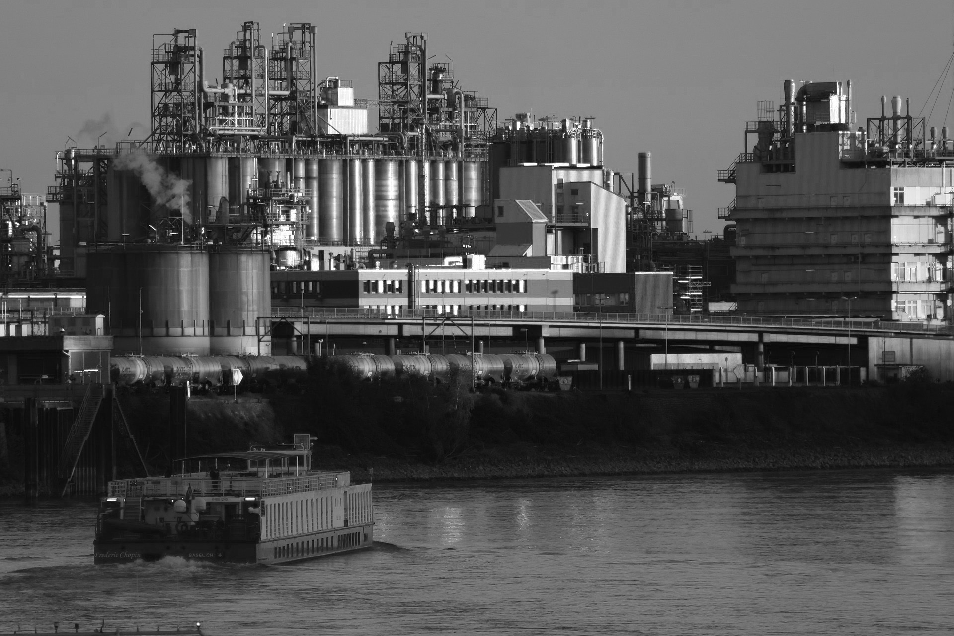 TM Security Werkschutz – industrielle Anlage am Fluss mit Sicherheitsüberwachung und Transportlogistik